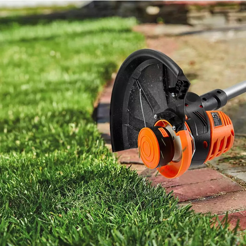 Gardening tool, possibly a weed wacker, being used on grass with a blurred background.