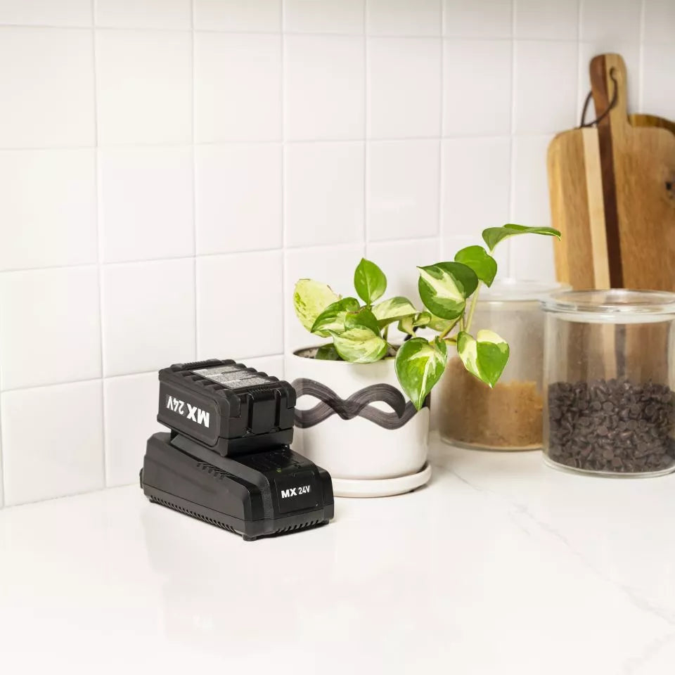 Black MX tool on a kitchen counter with a plant and jars in the background
