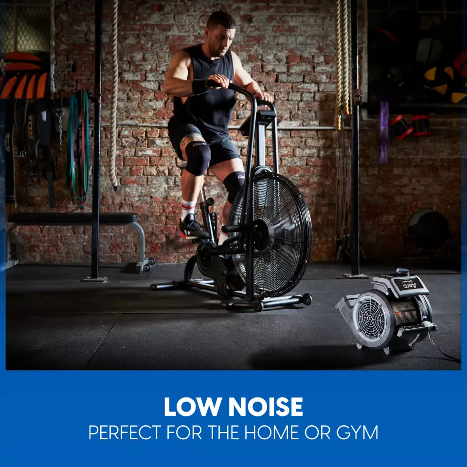 Person using a stationary bike in a gym setting with text 'Low Noise, Perfect for the Home or Gym'.