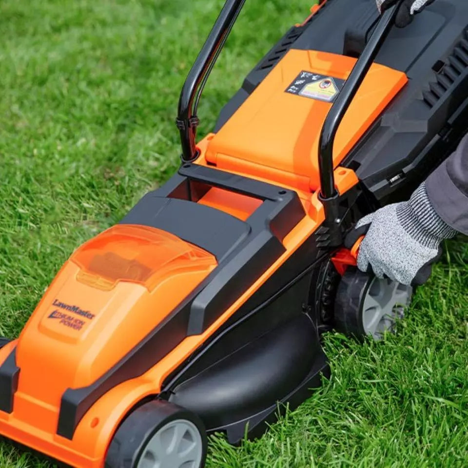 Orange and black lawn mower being used on grass