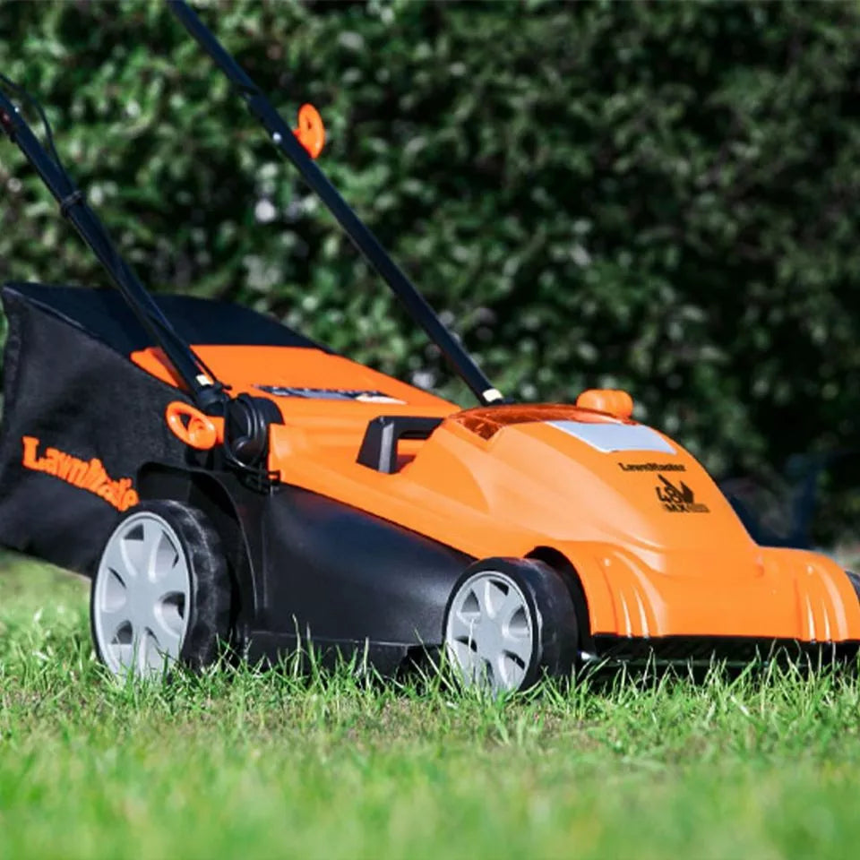 Orange and black lawn mower on grass with blurred greenery in the background