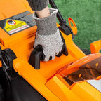 Person wearing a glove on an orange lawn mower with grass in the background