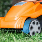 Orange robotic lawn mower on grass
