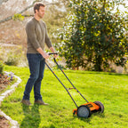 Man mowing grass with a lawn mower in a garden setting