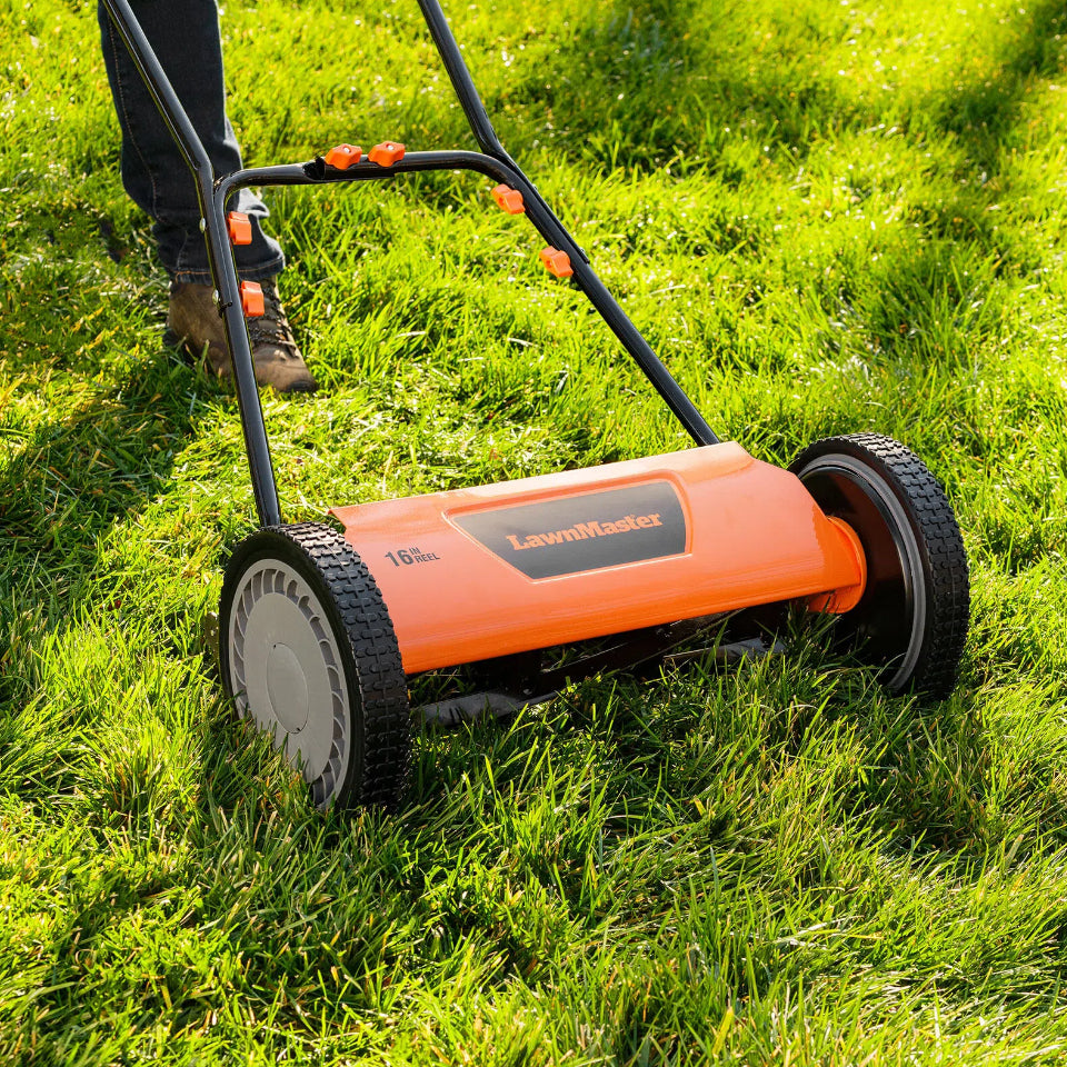 Orange LawnMaster lawn mower being used on a grassy area