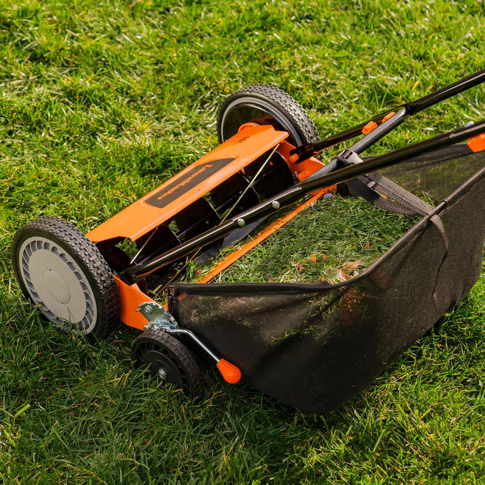 Orange and black lawn mower on grass