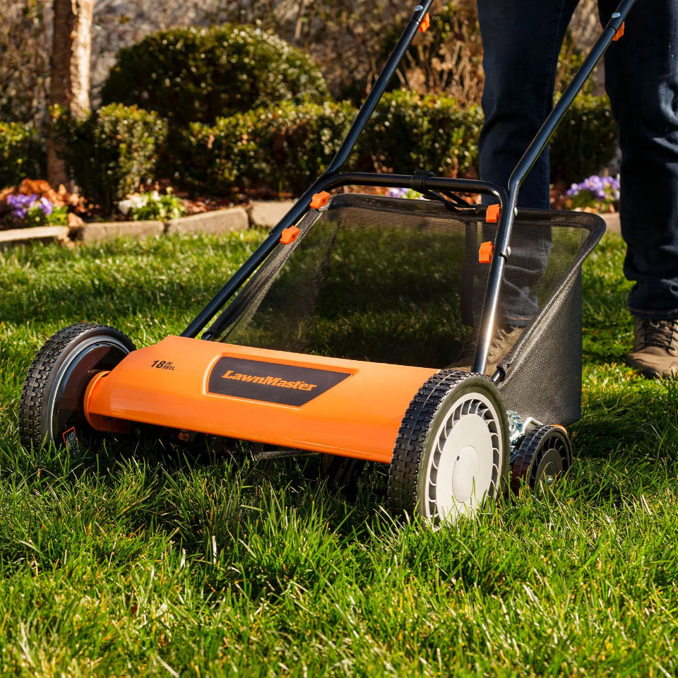 Orange LawnMower being used on a grassy area with a person partially visible.