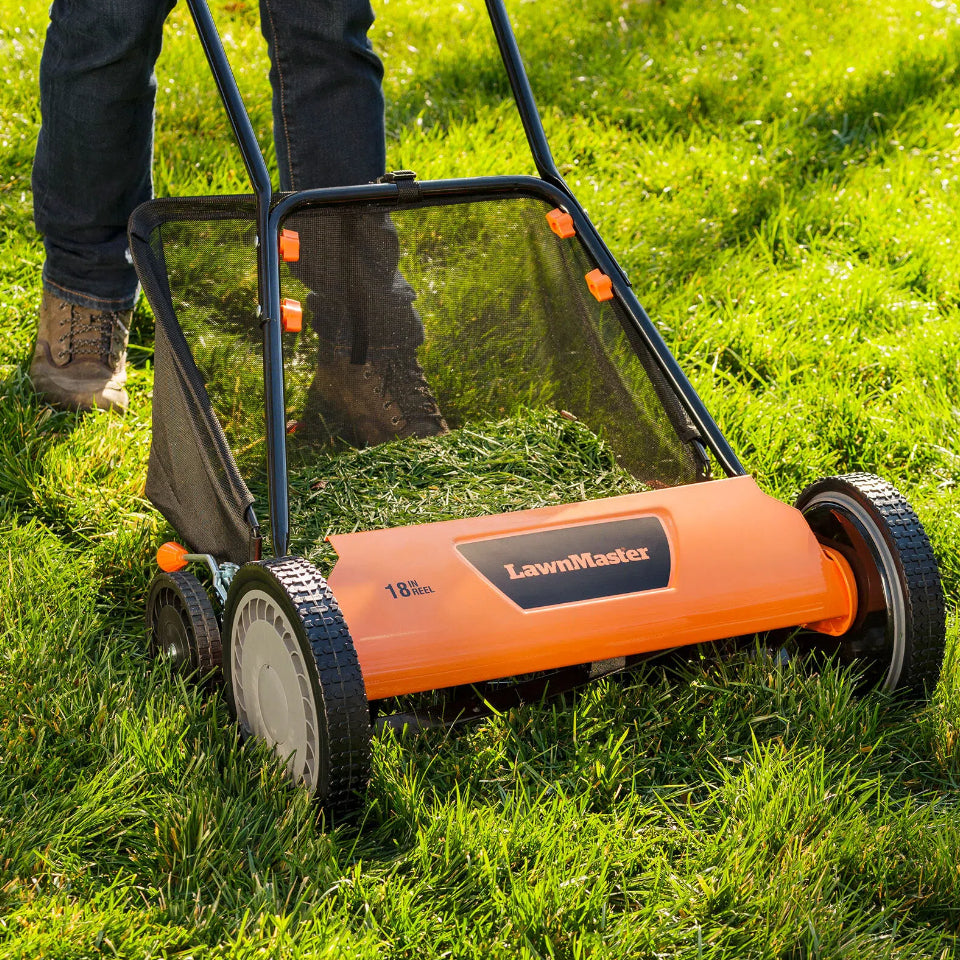 Person using a LawnMaster lawn mower on a grassy area