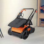 Orange and black snow blower on a white floor with a light-colored wall in the background.