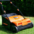 Orange and black lawn mower on a grassy area with blurred greenery in the background
