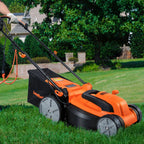 Orange and black lawn mower being used on a grassy area with trees and a house in the background.