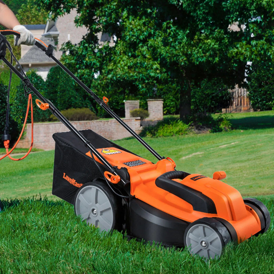 Orange and black lawn mower being used on a grassy area with trees and a house in the background.