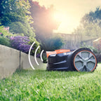 Robotic lawn mower cutting grass in a garden with sunlit background