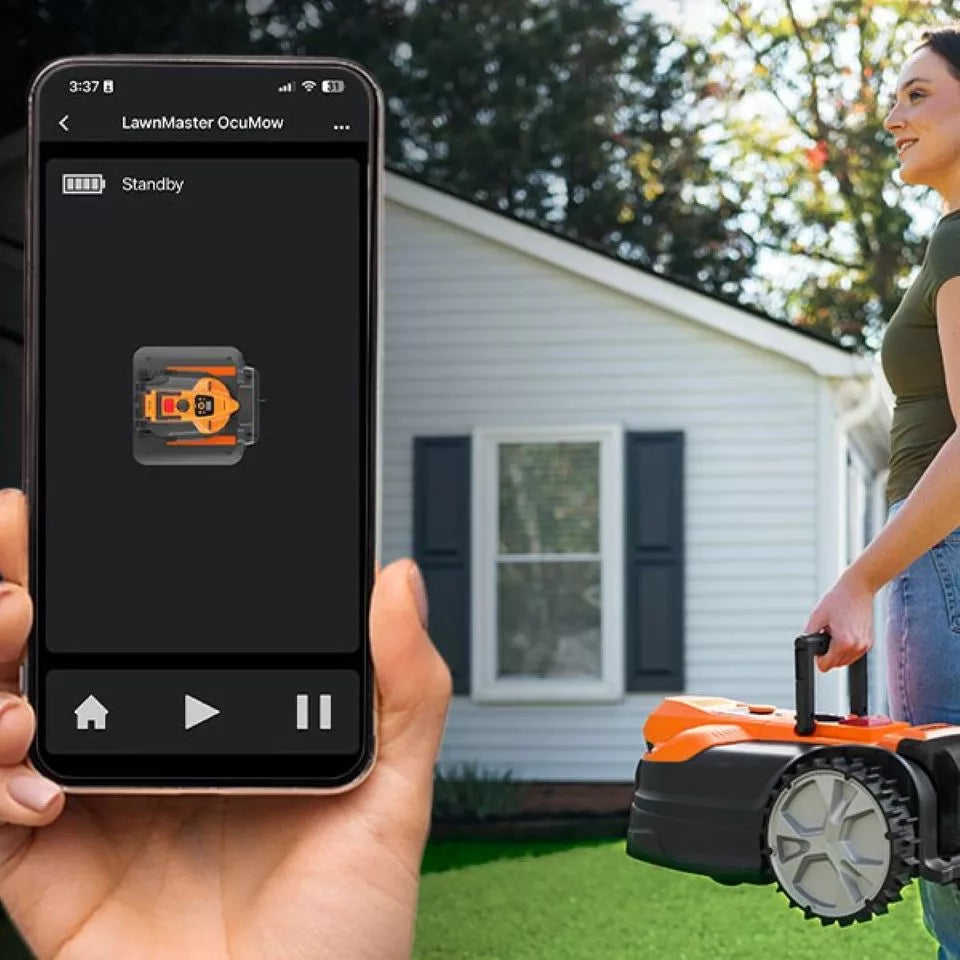 Person holding a smartphone with a lawn mower app displayed, next to a robot lawn mower in a backyard.