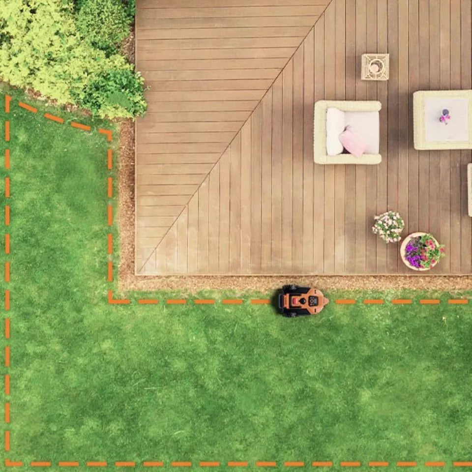 Top-down view of a wooden deck with outdoor furniture and plants on a grassy area.