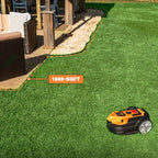 Robotic lawn mower on grass with '1600-SQFT' label in a backyard setting.
