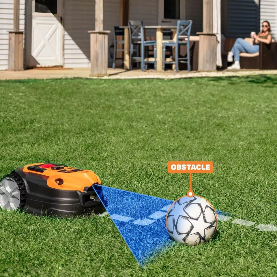 Robotic lawn mower on grass with a soccer ball labeled 'obstacle' nearby, in front of a house.