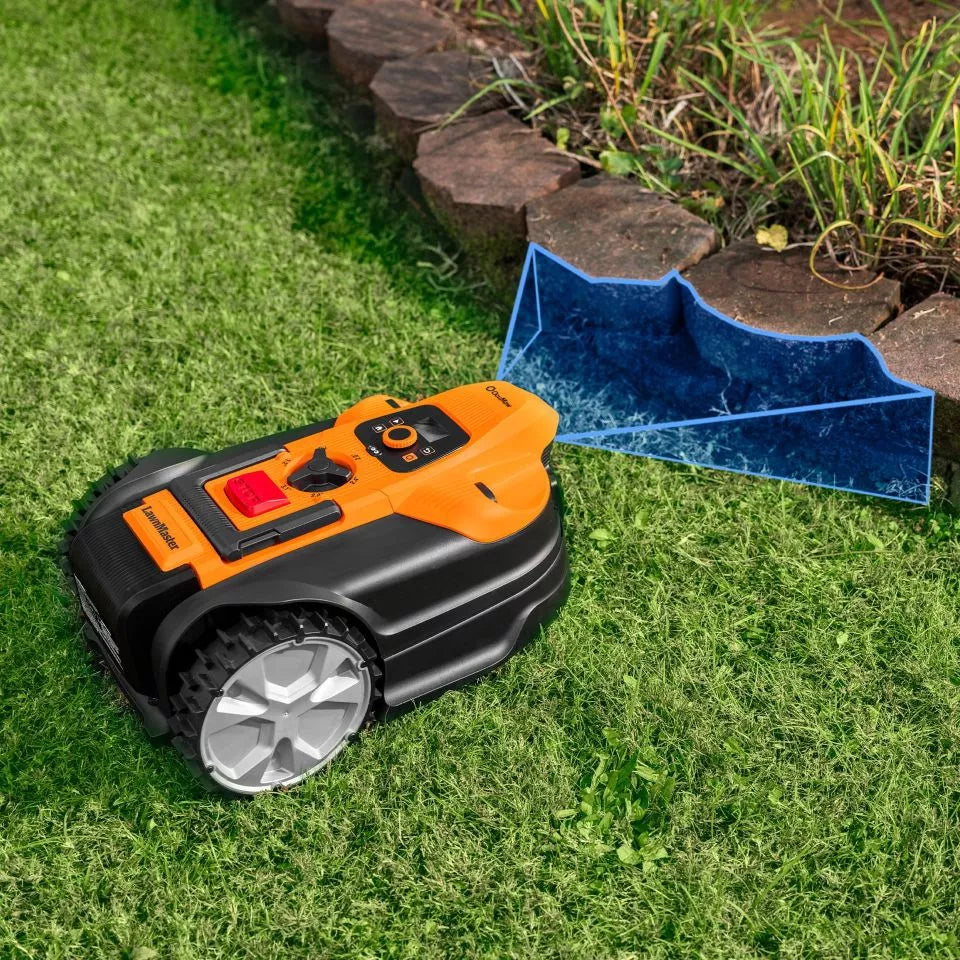 Robotic lawn mower on grass next to a stone border