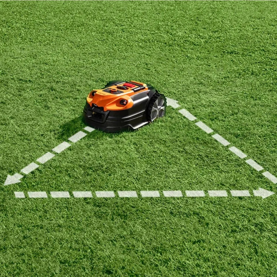 Robotic lawn mower on a green lawn with white lines marking a path.