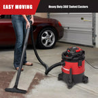 Person using a wet/dry vacuum with heavy-duty 360° swivel casters in a garage.