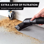 Hand using a vacuum cleaner to clean up debris with text about extra layer of filtration.