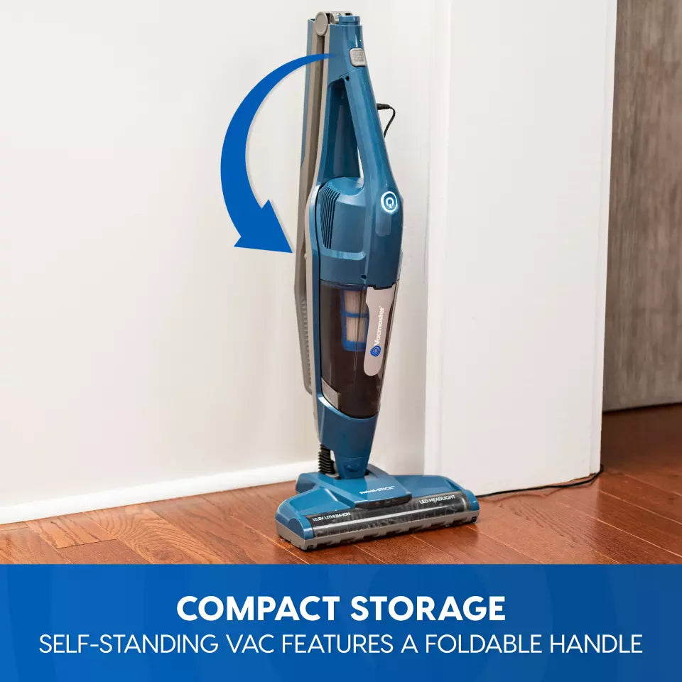 Blue vacuum cleaner with a foldable handle on a wooden floor, featuring text about compact storage.