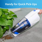 Handheld vacuum cleaner being used on a surface with text 'Handy for Quick Pick-Ups' and a plant in the background.